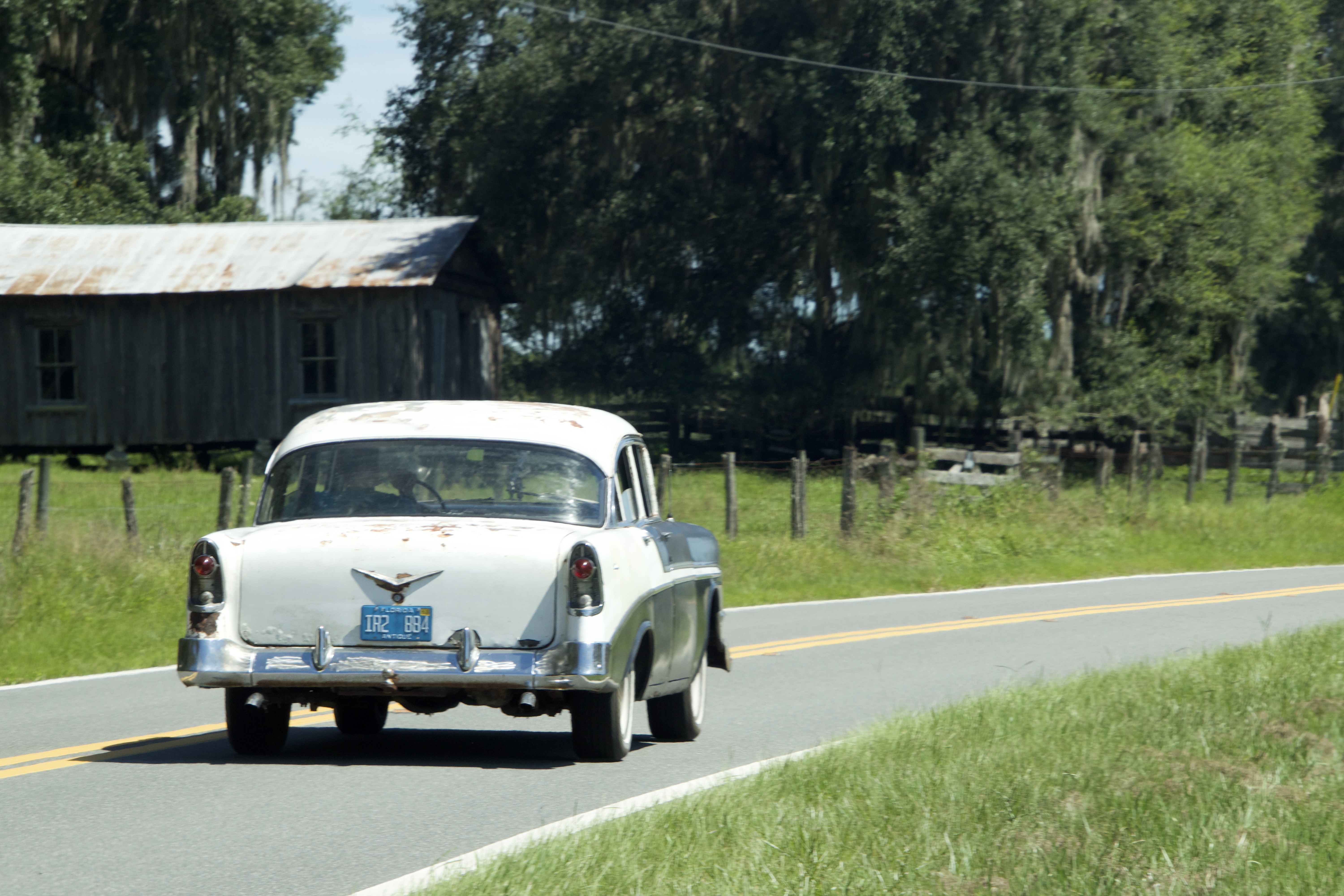 Vintage white car traveling a country road