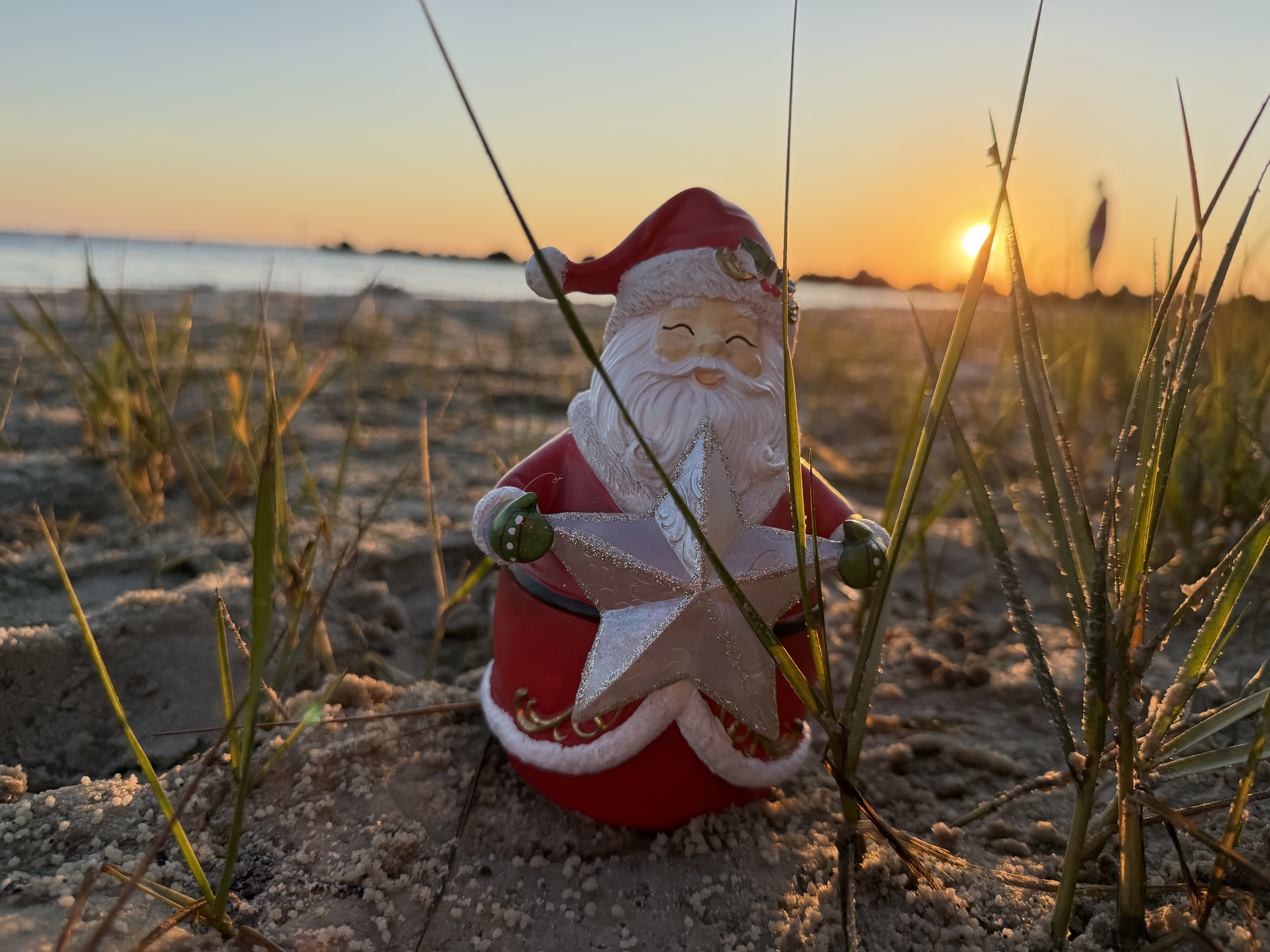 Santa figure watching a coastal sunset